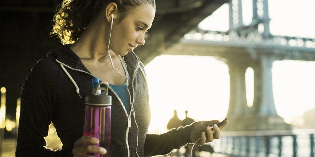 Young female runner holding water bottle, New York City, USA