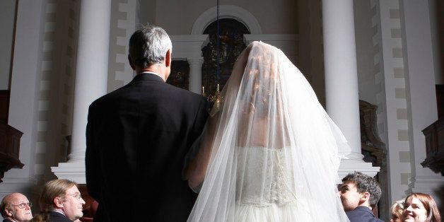 Father walking bride down church aisle, rear view