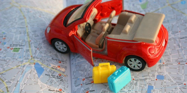 toy car on luggage on map of...