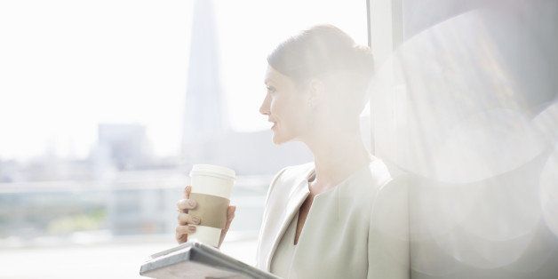 Businesswoman enjoying cup of coffee at window