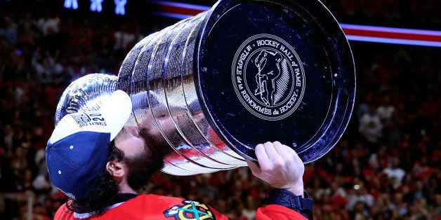 CHICAGO, IL - JUNE 15: Corey Crawford #50 of the Chicago Blackhawks celebrates by kissing the Stanley Cup after defeating the Tampa Bay Lightning by a score of 2-0 in Game Six to win the 2015 NHL Stanley Cup Final at the United Center on June 15, 2015 in Chicago, Illinois. (Photo by Tasos Katopodis/Getty Images)