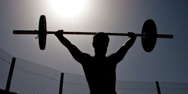 A participant in the 2011 Afghan Games power snatches a weighted bar on Sept. 10, 2011 at Kandahar Airfield, Afghanistan. During the second workout of the day, participants had to perform 50 burpees and as many power snatches as they could in a 10-minute period. Afghan Games is an annual Kandahar CrossFit event held to test the physical fitness levels of participants. (U.S. Air Force photo by Senior Airman David Carbajal)