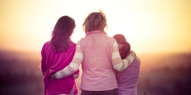 Rear view of mother and sisters watching sunset.