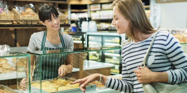 Clerk serving customer at deli counter in grocery store