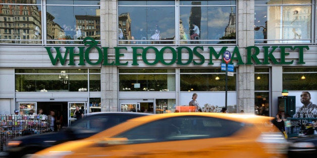 Pedestrians and motorists pass in front of a Whole Foods Market store in Union Square, Wednesday, June 24, 2015, in New York. New York City's consumer chief said Wednesday that Whole Foods supermarkets have been routinely overcharging customers by overstating the weight of prepackaged meat, dairy and baked goods. (AP Photo/Julie Jacobson)