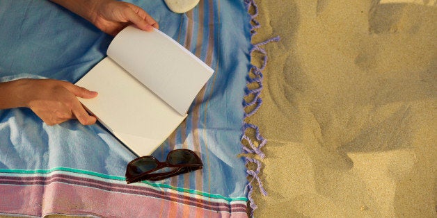 Woman on the beach reading a book