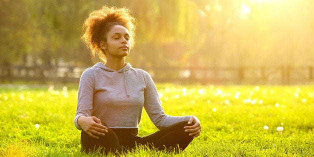 Young african american woman meditating in nature