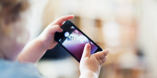 Male toddler playing with mobile phone