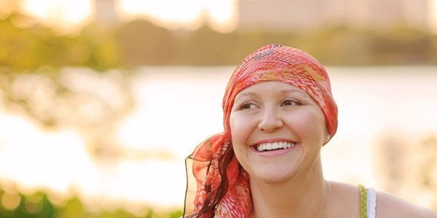 Smiling woman with cancer wearing scarf.