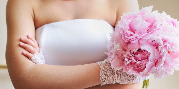 Discontented bride - young woman holding beautiful wedding flowers bouquet (peony)