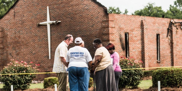 GREELEYVILLE, SC - JULY 1: People pray near the burned ruins of the Mt. Zion AME Church July 1, 2015 in Greeleyville, South Carolina. Federal and state agencies are investigating a recent string of church fires in the South that have occured since the church massacre in nearby Charleston, South Carolina. Mt. Zion AME was burned twenty years ago by members of the Ku Klux Klan. (Photo by Sean Rayford/Getty Images)