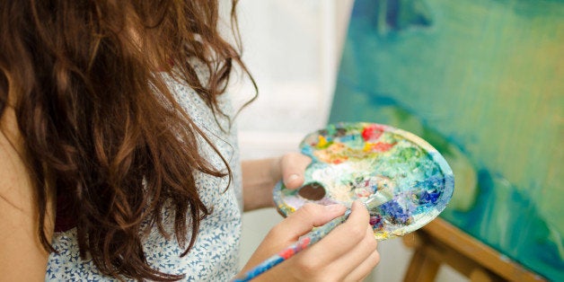 Woman painting and holding palette