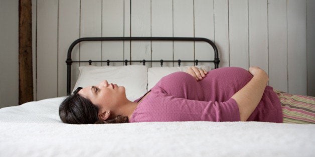 Pregnant woman lying on bed