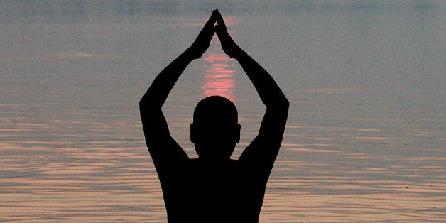 A Hindu devotee offers prayers to the sun god after taking holy dips in the River Ganges on the occasion of Anant Chaturdashi festival in Mirzapur, India, Friday, Sept. 28, 2012. The annual Anant Chaturdashi festival is the culmination of ten days when members of the Jain community reflect upon the past year to take steps towards purifying the soul and taking steps towards ten aspects that include giving and seeking forgiveness, prayers and meditation, non-violence towards all living beings, and riding the soul of jealousy, egoism and anger. (AP Photo/Anshul Mishra)