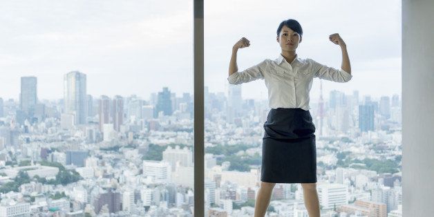 Business woman flexing muscles with city view.