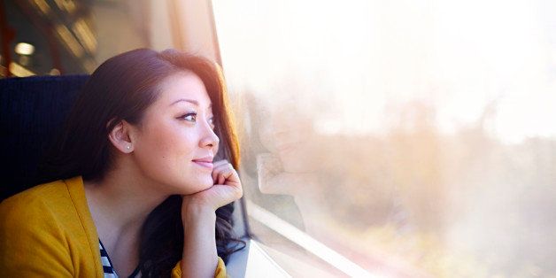 Woman on a train day dreaming out the window.