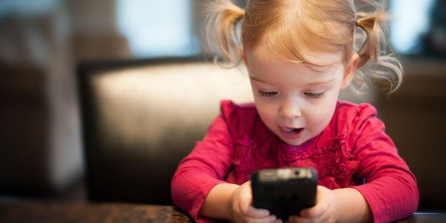 Little girl looking at phone.