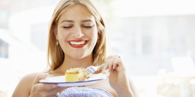 woman smiling and eating cake