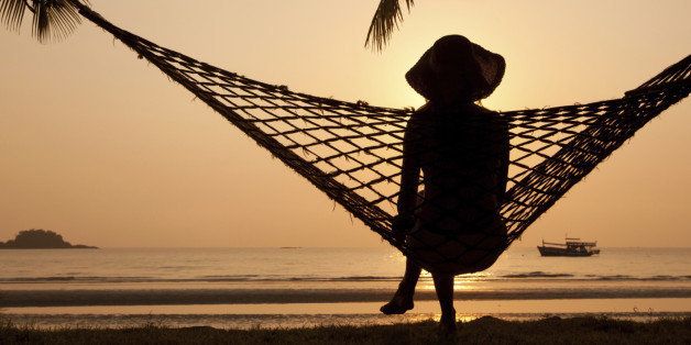 woman in hammock enjoying sunset on the beach