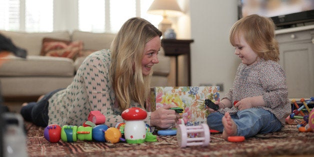 Mother and daughter playing with toys on living room floor