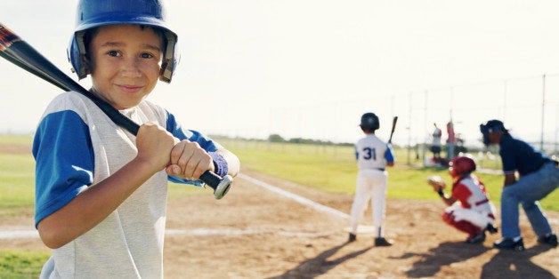 Little league player standing on side getting ready to play