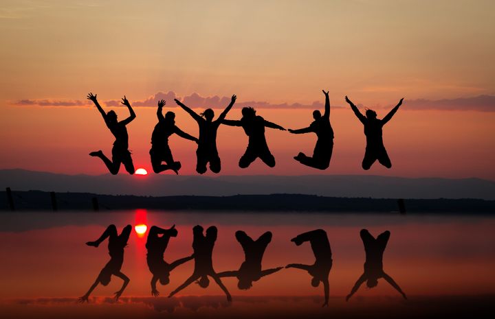 friends jumping in sunset