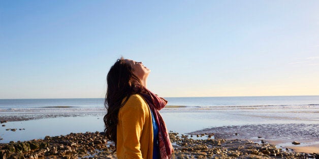 Woman on the beach breathing in the fresh air