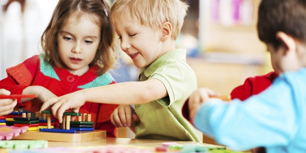 Cute cheerful children playing with toys. The focus is on the blonde boy.