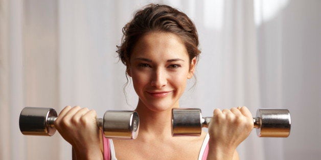 Young woman holding dumb-bells