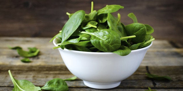 spinach in the bowl on the dark wood background. toning.