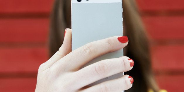 woman holding up phone to take selfie