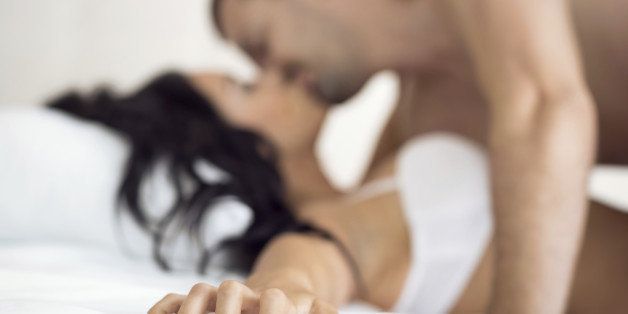 Couple having sex, female hand grabbing sheet