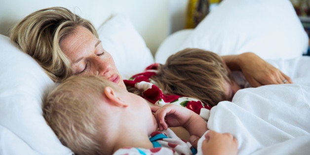 Mother with sons sleeping in bed