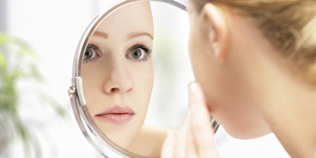 face of young beautiful healthy woman and reflection in the mirror