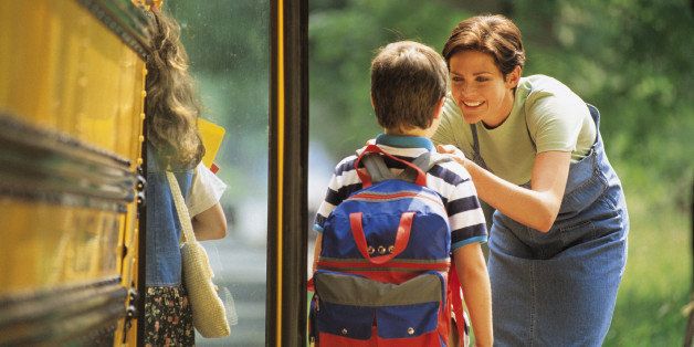 Mother sending son off to school at bus stop
