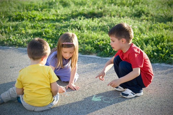 Kids playing on the ground in a sunny day.