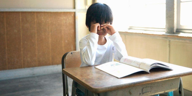 Boy (5-7) crying in school classroom