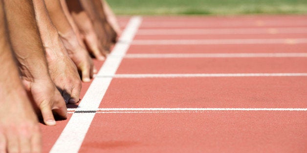 Runners crouched at starting line, cropped