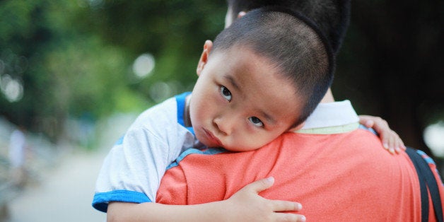 Unhappy boy on papa's shoulder.