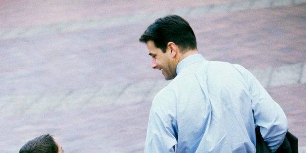 Rear view of a father and his son holding hands