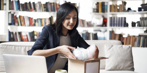 Woman preparing parcel for shipment in her cozy loft apartment