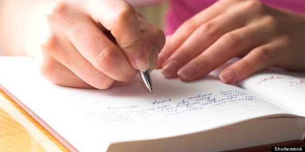 Young female is writing notes and planning her schedule.