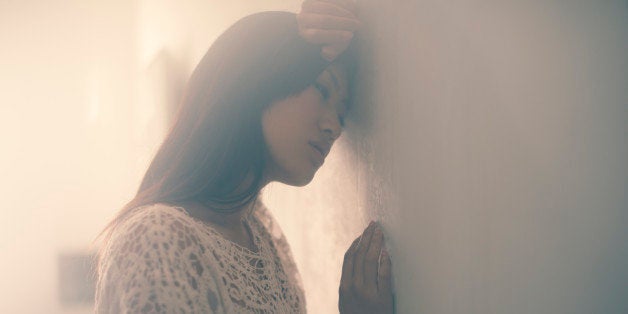 Asian woman leaning on the wall.