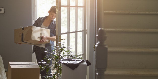 And woman carrying a packing box into her new home