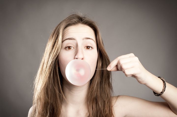 young woman making a bubble...