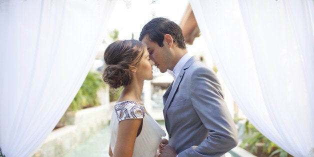 Bride and groom kissing at wedding alter