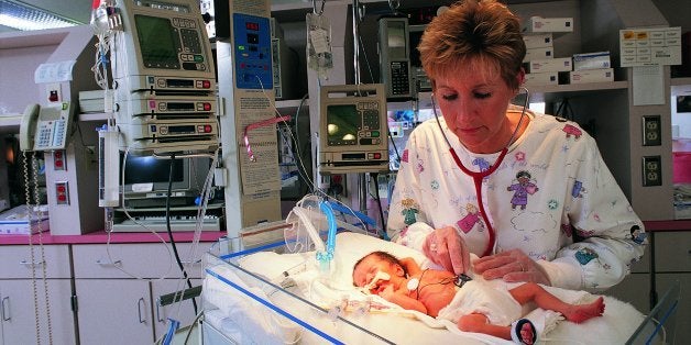 Nurse checking premature baby in intensive care