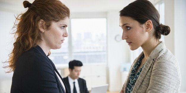 Businesswomen glaring at each other in office