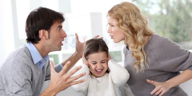 Child hiding from her parents shouting at each other