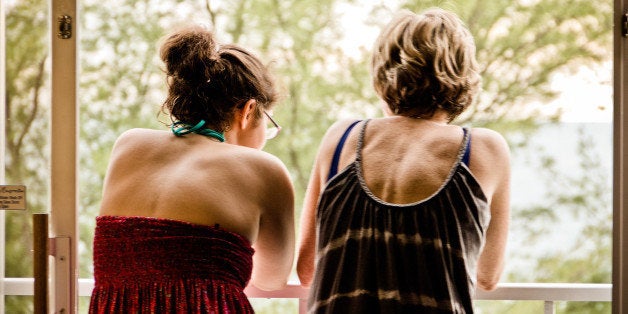 Mother and daughter conversing on balcony.